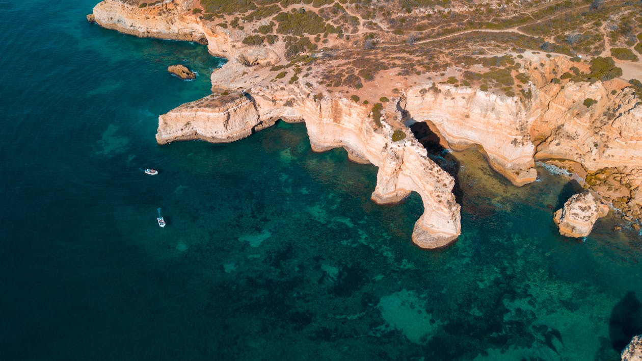 Algarve Portugal limestone cliffs above clear beach